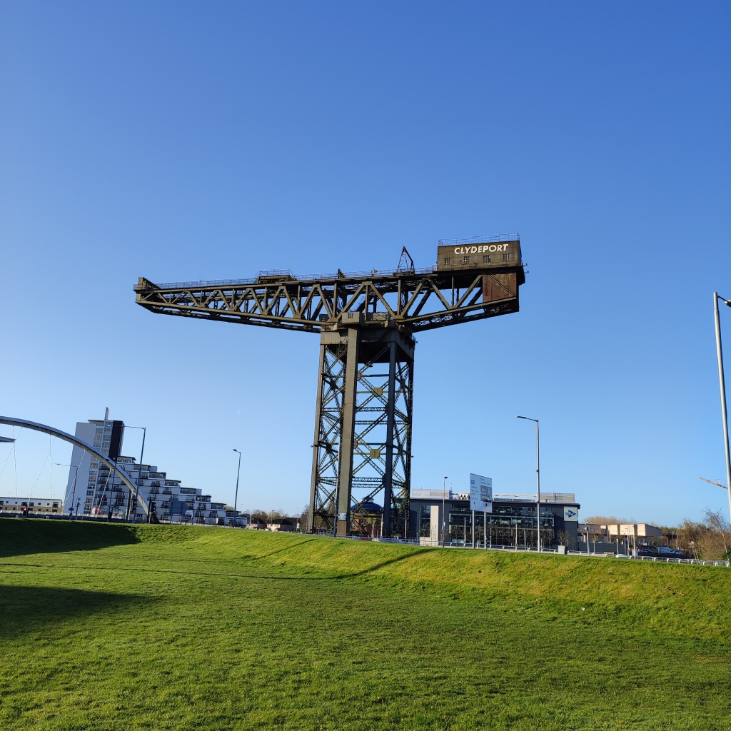 large crane on grass with a blue sky behind